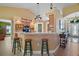 Open kitchen with breakfast bar, wood cabinetry, and modern appliances blending seamlessly with the living space at 397 Anderson Dr, Tavares, FL 32778
