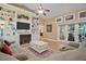 Bright living room featuring built-in bookshelves, fireplace, French doors, and ceiling fan at 397 Anderson Dr, Tavares, FL 32778