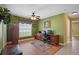 This home office features wood floors, green walls, a ceiling fan, and a large window at 397 Anderson Dr, Tavares, FL 32778