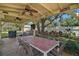 Covered outdoor patio features ceiling fans, a large table and BBQ grill for relaxed outdoor dining and entertaining at 397 Anderson Dr, Tavares, FL 32778