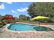 Freeform pool is surrounded by brick pavers, manicured landscaping, and patio furniture with umbrellas at 397 Anderson Dr, Tavares, FL 32778