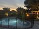 Backyard pool with fence and outdoor fire pit area at dusk provides a relaxing and safe environment at 397 Anderson Dr, Tavares, FL 32778