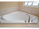 Corner bathtub with tile surround is situated next to a window for natural light and ventilation at 397 Anderson Dr, Tavares, FL 32778