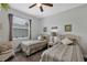 Guest bedroom features two beds, a large window, ceiling fan and view of well manicured yard at 4581 Shenandoah River Trl, Leesburg, FL 34748
