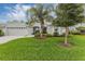 Inviting single-story home with a lush green lawn and a mature shade tree in the front yard at 4581 Shenandoah River Trl, Leesburg, FL 34748