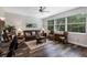 Comfortable living room with leather furniture, ceiling fan, and natural lighting at 4581 Shenandoah River Trl, Leesburg, FL 34748