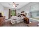 Bright main bedroom with a ceiling fan and view of lush backyard provides a peaceful retreat at 4581 Shenandoah River Trl, Leesburg, FL 34748