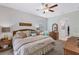 Comfortable main bedroom features a large ceiling fan, relaxing decor and access to the main bathroom at 4581 Shenandoah River Trl, Leesburg, FL 34748