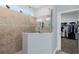 Walk-in shower with a tiled surround, glass partition, and a view into a large walk-in closet at 4581 Shenandoah River Trl, Leesburg, FL 34748