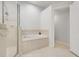 Clean bathroom featuring a soaking tub, glass shower, and neutral tile work at 4716 Block Island Ln, Clermont, FL 34714