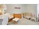 Sweet Bedroom featuring a wooden crib, changing table, and rocking chair, creating a comforting environment at 4716 Block Island Ln, Clermont, FL 34714