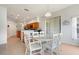 Charming dining area with a glass table set, tile floors, and natural light from large windows at 4716 Block Island Ln, Clermont, FL 34714