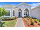 Inviting front entrance with brick walkway, lush landscaping, arched entryway, and a cozy bench at 4716 Block Island Ln, Clermont, FL 34714