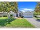 Charming one-story home featuring a well-manicured lawn, mature tree, and a two-car garage on a sunny day at 4716 Block Island Ln, Clermont, FL 34714