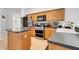 Well-equipped kitchen with stainless steel appliances, wooden cabinetry, and solid surface countertops at 4716 Block Island Ln, Clermont, FL 34714