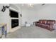 Cozy living room featuring a fireplace, plush carpet, and a comfortable leather couch at 4716 Block Island Ln, Clermont, FL 34714