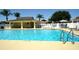 Community pool area boasts lounge chairs, tables, and covered seating, for a relaxing experience at 4716 Block Island Ln, Clermont, FL 34714