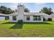 Green backyard showcasing the home's exterior, chimney, and well-maintained lawn at 508 Woodview Dr, Tavares, FL 32778