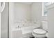Bathroom with a soaking tub featuring white marble surround and a toilet at 508 Woodview Dr, Tavares, FL 32778