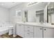 Bright bathroom featuring a double vanity, large mirror, and a soaking tub with a window at 508 Woodview Dr, Tavares, FL 32778