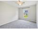 Bedroom featuring neutral carpet, a ceiling fan, and a window overlooking the yard at 508 Woodview Dr, Tavares, FL 32778