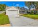 Charming single-Gathering home with manicured lawn, two-car garage and driveway starburst detail at 508 Woodview Dr, Tavares, FL 32778
