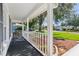Covered front porch area features a white railing and view of the green lawn and neighborhood at 508 Woodview Dr, Tavares, FL 32778