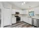 Well-lit kitchen featuring white cabinets, stainless steel appliances, and durable gray flooring at 508 Woodview Dr, Tavares, FL 32778