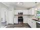 Well-lit kitchen featuring white cabinets, stainless steel appliances, and durable gray flooring at 508 Woodview Dr, Tavares, FL 32778