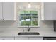 Bright kitchen features granite countertops, stainless steel sink, modern faucet, and window with view at 508 Woodview Dr, Tavares, FL 32778