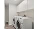 Laundry room featuring a front-load washer and dryer and storage cabinets at 508 Woodview Dr, Tavares, FL 32778