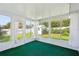 Bright sunroom with large windows offering serene backyard views and lush green carpet at 508 Woodview Dr, Tavares, FL 32778
