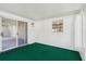 Enclosed patio featuring textured walls, green carpet, and sliding glass doors at 508 Woodview Dr, Tavares, FL 32778