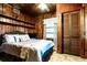 Comfortable bedroom with wood paneled walls, shelving, and window with natural light at 513 Barwick St, Wildwood, FL 34785