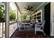 Inviting screened front porch with wicker furniture, a hanging swing, ceiling fan, and brick-look flooring at 513 Barwick St, Wildwood, FL 34785