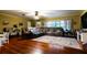 Spacious living room featuring hardwood floors, a large sectional sofa, and natural light from a window at 513 Barwick St, Wildwood, FL 34785