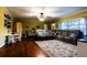 Bright living room with hardwood floors, a comfortable sectional sofa, and a view of the front yard at 513 Barwick St, Wildwood, FL 34785