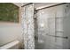 This bathroom features a glass-enclosed shower with leaf-patterned shower curtain and art at 5333 Loblolly Ln, Wildwood, FL 34785