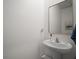 Powder room with a pedestal sink, modern faucet, and stylish mirror at 5333 Loblolly Ln, Wildwood, FL 34785