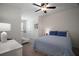 This charming bedroom features a ceiling fan, a plush bed, and a cozy crib in the corner at 5333 Loblolly Ln, Wildwood, FL 34785