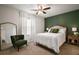 Comfortable bedroom featuring a stylish accent wall, ceiling fan, and a queen-sized bed at 5333 Loblolly Ln, Wildwood, FL 34785