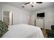 Bright bedroom with a ceiling fan, ensuite bathroom, a walk-in closet, and a television at 5333 Loblolly Ln, Wildwood, FL 34785