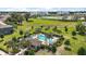 Aerial view of the community pool and clubhouse area surrounded by landscaped greenery and residences at 5333 Loblolly Ln, Wildwood, FL 34785