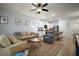 Comfortable living room with a ceiling fan, neutral tones, and a view into the kitchen and breakfast nook at 5333 Loblolly Ln, Wildwood, FL 34785