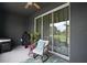 Covered patio with grill, comfortable seating, and sliding glass doors leading to the backyard at 5333 Loblolly Ln, Wildwood, FL 34785