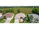 Aerial view of single-story home with well-manicured lawn, attached garage, and a view of the pond at 541 Carrera Dr, The Villages, FL 32159