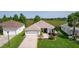 Aerial view highlights the home's curb appeal, lush landscaping, and serene surroundings under a clear sky at 541 Carrera Dr, The Villages, FL 32159
