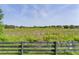 Serene backyard view overlooking lush greenery with a rustic wooden fence, offering privacy and a connection with nature at 541 Carrera Dr, The Villages, FL 32159