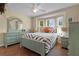 Bedroom with wood floors features a bay window and painted wood furniture at 541 Carrera Dr, The Villages, FL 32159