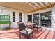 Covered patio with comfortable seating, ideal for outdoor dining and relaxation, overlooking the backyard at 541 Carrera Dr, The Villages, FL 32159